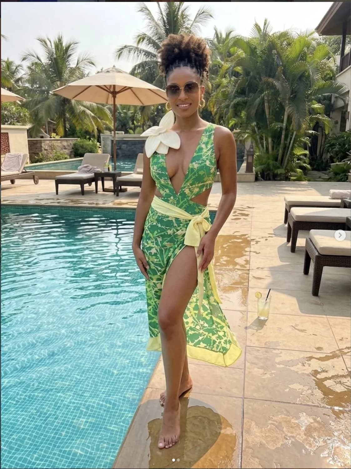 Aisha in a green Mayoni cover-up beside a palm-lined resort pool