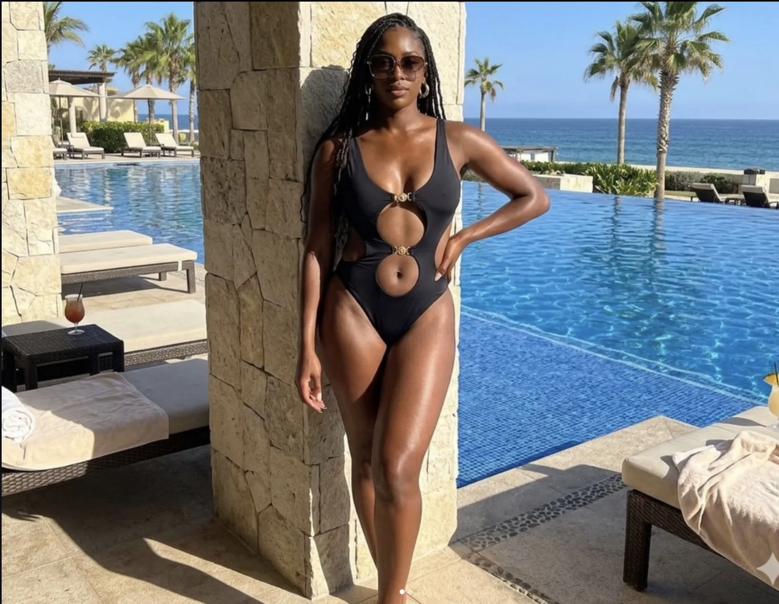 Woman in a black cutout one-piece swimsuit at an oceanfront villa